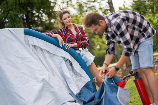 Young nice couple having fun on camping setting up tent — Foto Stock