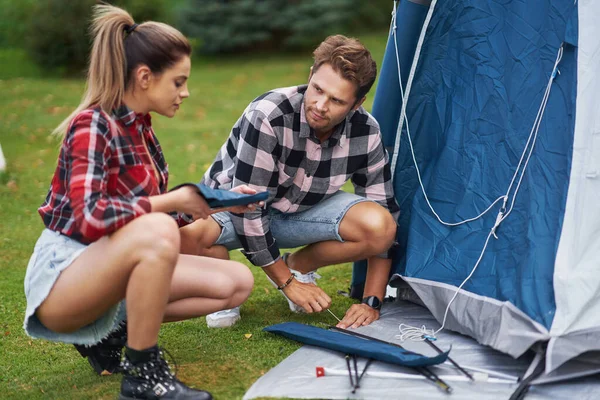 Young nice couple having fun on camping setting up tent — Foto Stock