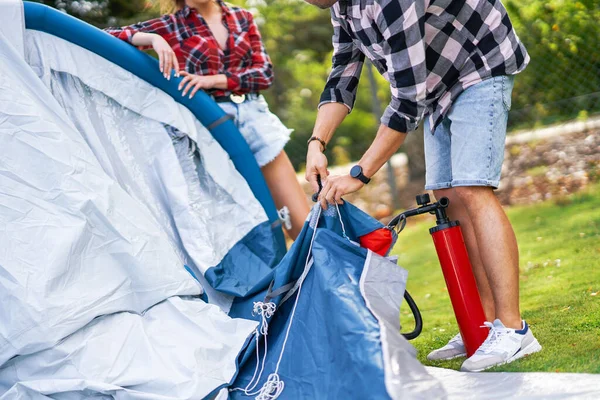 Jovem casal agradável se divertindo no acampamento criação de tenda — Fotografia de Stock