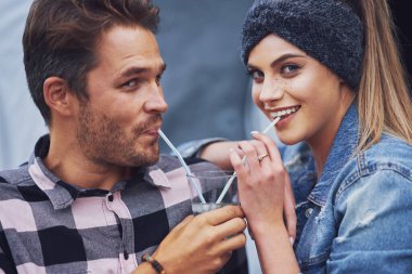 Young nice couple having fun on camping sharing drink