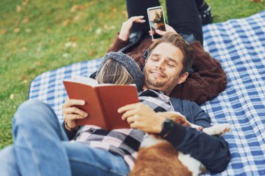 Genç ve hoş bir çift köpekle kamp yapıyor.