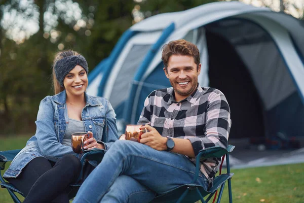 Giovane bella coppia seduta su sedie inf davanti alla tenda in campeggio — Foto Stock