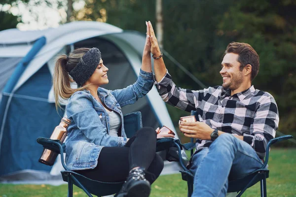 Giovane bella coppia seduta su sedie inf davanti alla tenda in campeggio — Foto Stock