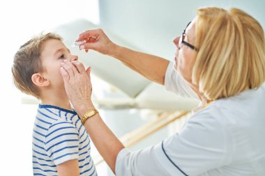 Çocuk doktoru. Klinikteki küçük çocukları muayene ediyor.