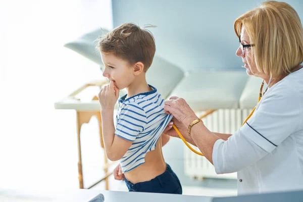 Médico pediatra examinando a niños pequeños en clínica — Foto de Stock