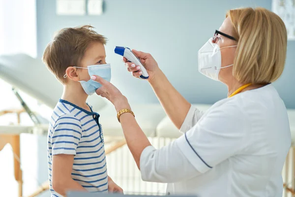 Pediatriker läkare undersöker små barn på kliniken temperatur kontroll — Stockfoto