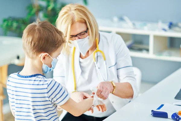 Médico pediatra examinando a niños pequeños en clínica —  Fotos de Stock