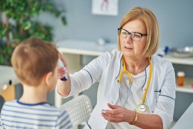 Pediyatrist doktor küçük çocukları muayene ediyor.