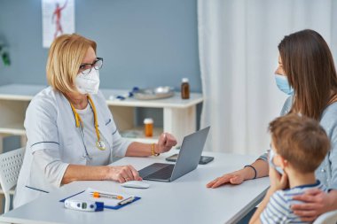 Çocuk doktoru. Klinikteki küçük çocukları muayene ediyor.