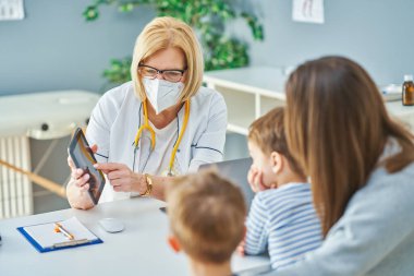 Çocuk doktoru. Klinikteki küçük çocukları muayene ediyor.