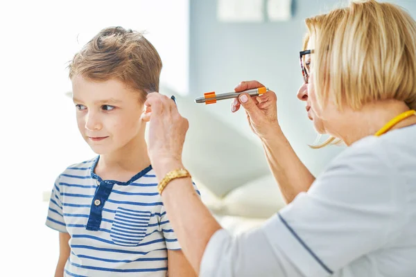Kinderarts arts onderzoeken van kleine kinderen in kliniek oren controleren — Stockfoto
