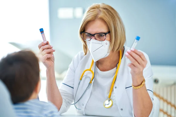 Kinderarts onderzoekt kleine kinderen in kliniek bloedtest — Stockfoto