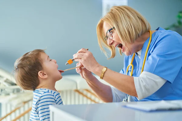 Médico pediatra examinando a niños pequeños en clínica — Foto de Stock