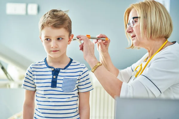 Kinderarts arts onderzoeken van kleine kinderen in kliniek oren controleren — Stockfoto