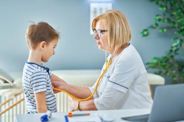 Çocuk doktoru. Klinikteki küçük çocukları muayene ediyor.