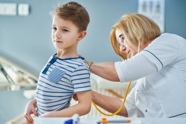 Çocuk doktoru. Klinikteki küçük çocukları muayene ediyor.