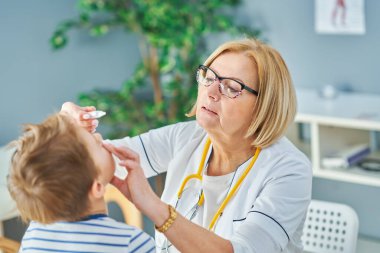 Çocuk doktoru. Klinikteki küçük çocukları muayene ediyor.