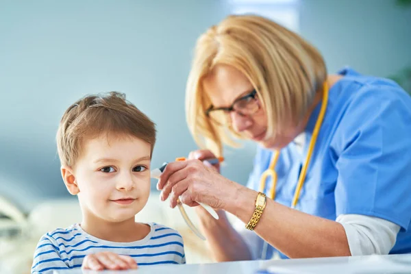Лікар педіатр вивчає маленьких дітей у клінічній перевірці вух — стокове фото