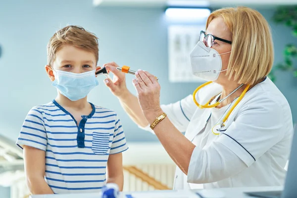 Kinderarts arts onderzoeken van kleine kinderen in kliniek oren controleren — Stockfoto