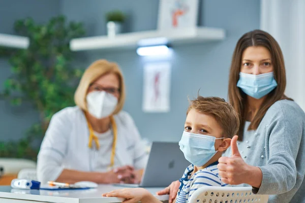 Médico pediatra examinando a niños pequeños en clínica —  Fotos de Stock