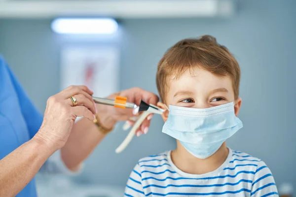 Pediatriker läkare undersöker små barn på kliniken öron kontrollera — Stockfoto