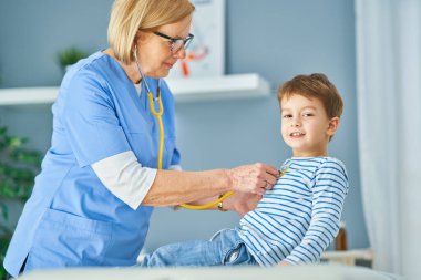 Çocuk doktoru. Klinikteki küçük çocukları muayene ediyor.