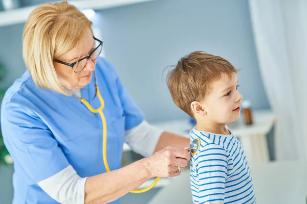 Pediatrician doctor examining little kids in clinic — Stock Photo, Image