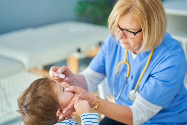 Pediatrician doctor examining little kids in clinic — Stock Photo, Image