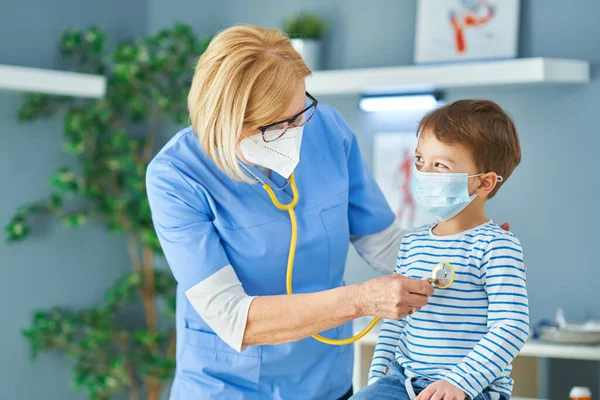 Pediatrician doctor examining little kids in clinic — Stock Photo, Image