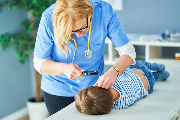 Pediatrician doctor examining little kids in clinic ears check — Stock Photo, Image