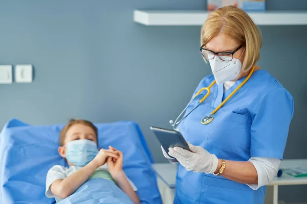 Mujer adulta y paciente joven en cama de hospital — Foto de Stock