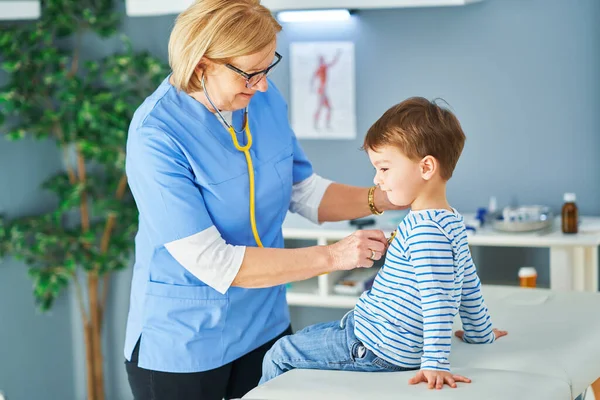 Gyermekorvos kisgyerekeket vizsgál a klinikán. — Stock Fotó