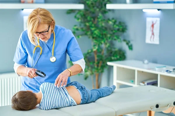 Pediatrician doctor examining little kids in clinic ears check — Stock Photo, Image