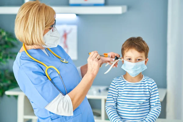 Pediatriker läkare undersöker små barn på kliniken öron kontrollera — Stockfoto