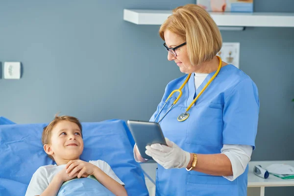 Femme adulte et jeune patient dans un lit d'hôpital — Photo