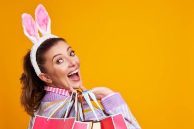 Sarı arkaplan üzerindeki kadının stüdyo fotoğrafları. Paskalya tarzı.