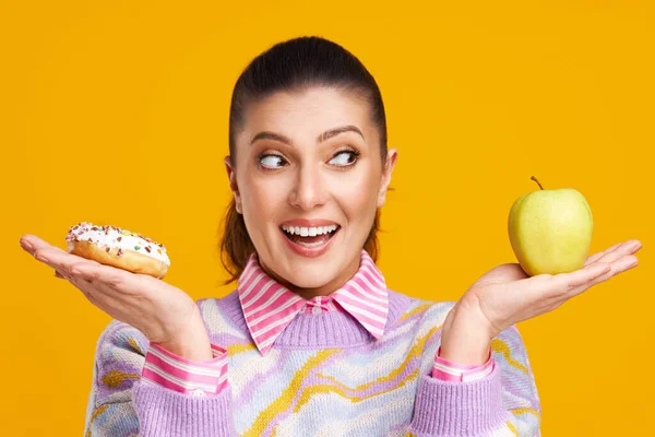 Jovem bela mulher sobre fundo amarelo com donuts — Fotografia de Stock