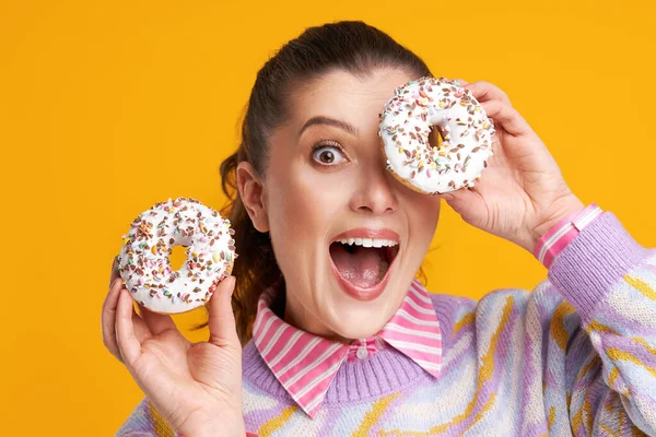 Junge schöne Frau auf gelbem Hintergrund mit Donuts — Stockfoto