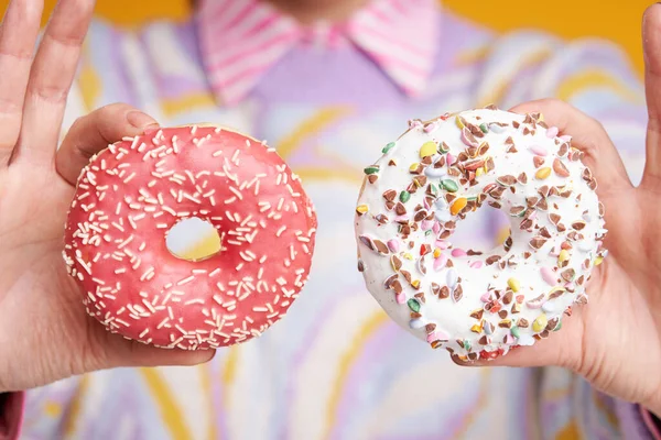 Jonge mooie vrouw over gele achtergrond met donuts — Stockfoto