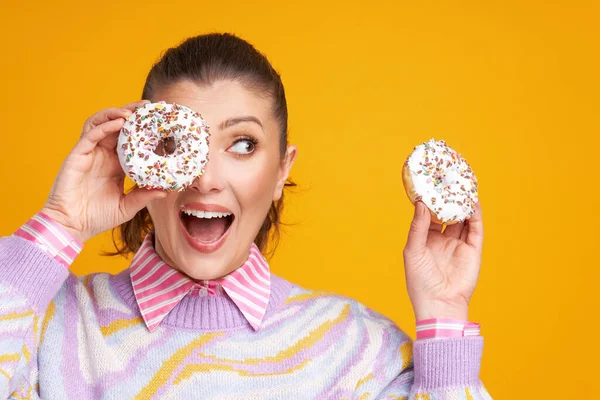 Junge schöne Frau auf gelbem Hintergrund mit Donuts — Stockfoto