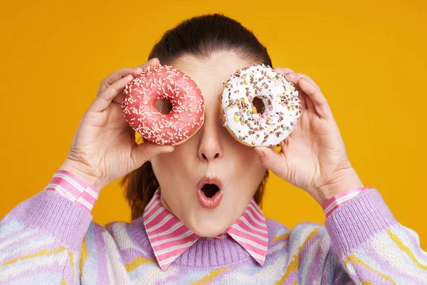 Jovem bela mulher sobre fundo amarelo com donuts — Fotografia de Stock