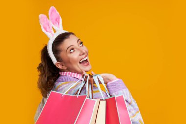 Sarı arkaplan üzerindeki kadının stüdyo fotoğrafları. Paskalya tarzı.