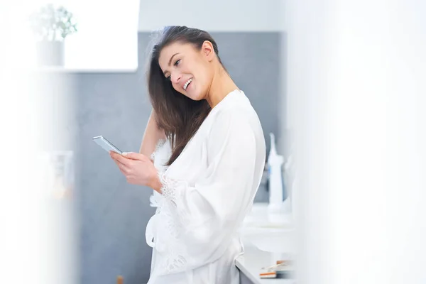 Jong mooi brunette vrouw in de badkamer — Stockfoto