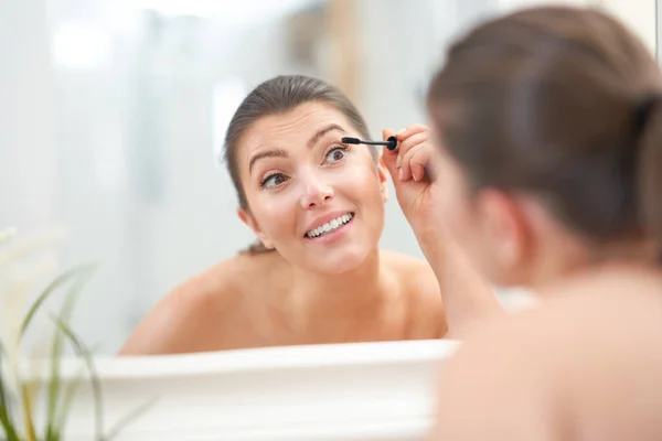 Jong mooi brunette vrouw in de badkamer — Stockfoto