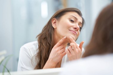 Genç, güzel, esmer kadın banyoda.