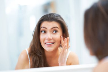 Genç, güzel, esmer kadın banyoda.