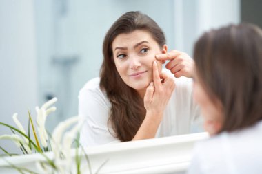 Genç, güzel, esmer kadın banyoda.