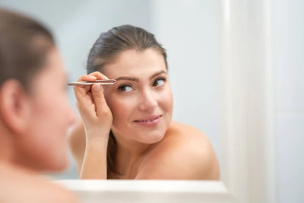 Jong mooi brunette vrouw in de badkamer — Stockfoto