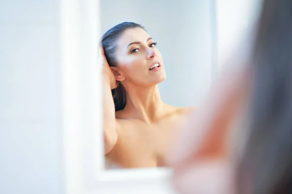 Jong mooi brunette vrouw in de badkamer — Stockfoto