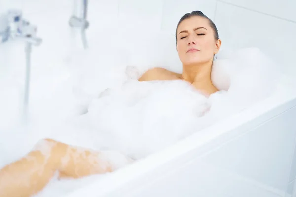 Young nice brunette woman having bath in bathtub — Stock Photo, Image